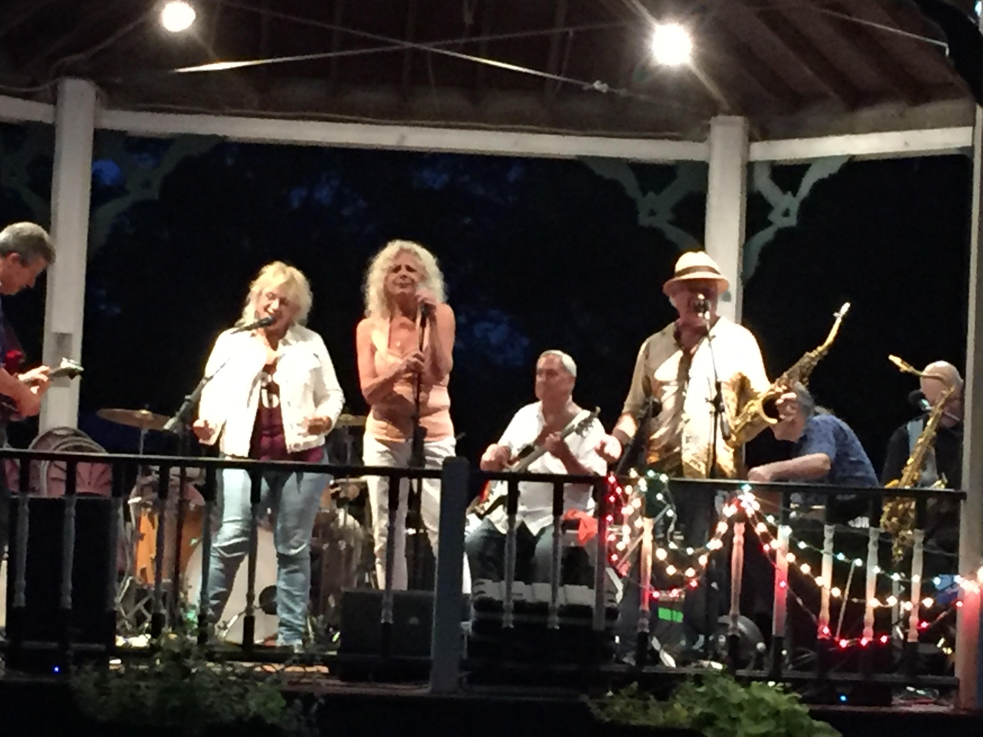 Two vocalists sharing the mic during a summer concert at the Wood Park gazebo.