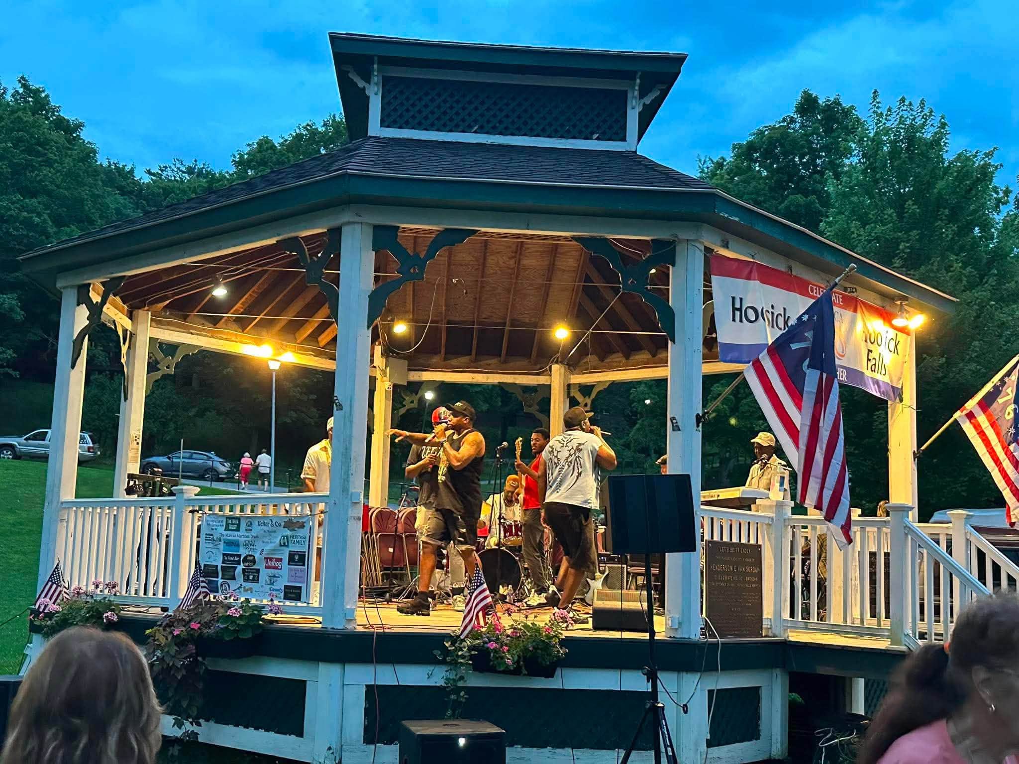The Wood Park gazebo glowing at dusk as Legacy Music Group plays under the lights.