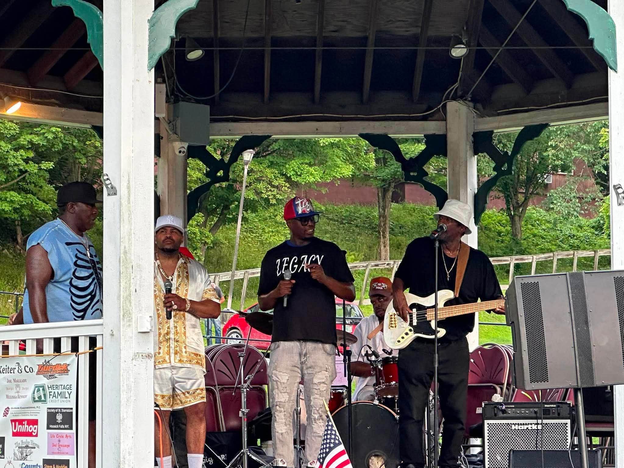 Legacy Music Group singing at the Wood Park gazebo, five vocalists and a bassist under the rafters.