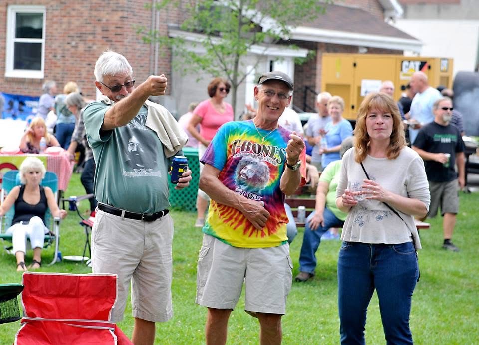 Neighbors clapping and dancing along to the music on the lawn.