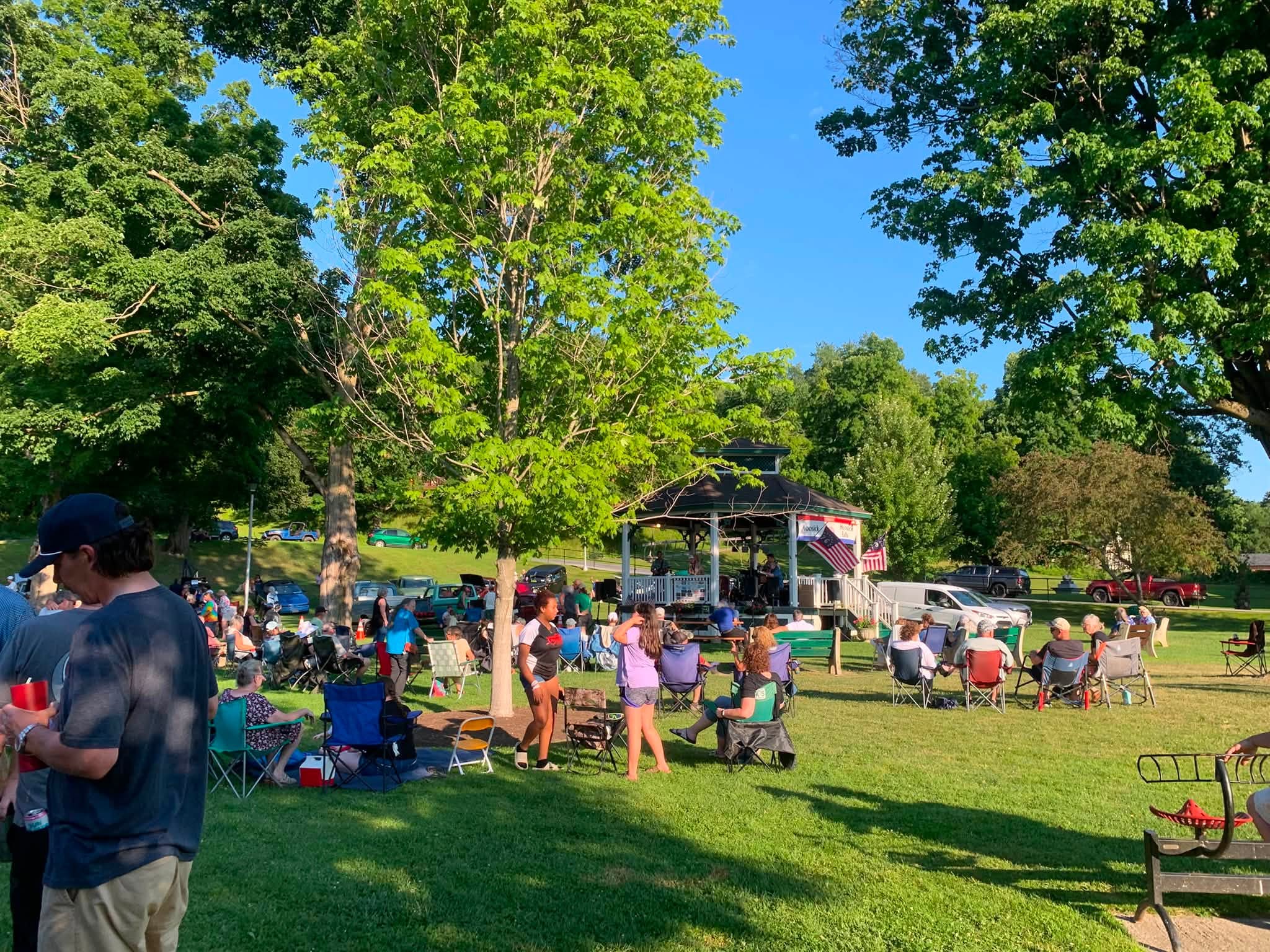 Neighbors filling the Wood Park lawn with chairs and blankets as the band plays at the gazebo.